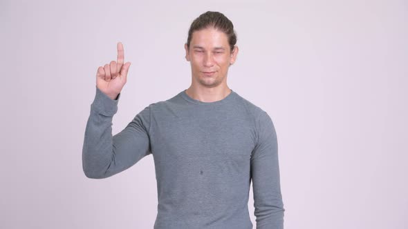 Happy Handsome Man Pointing Finger Up Against White Background