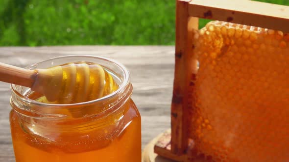 Honey Dipper is Collecting Delicious Honey From a Glass Jar