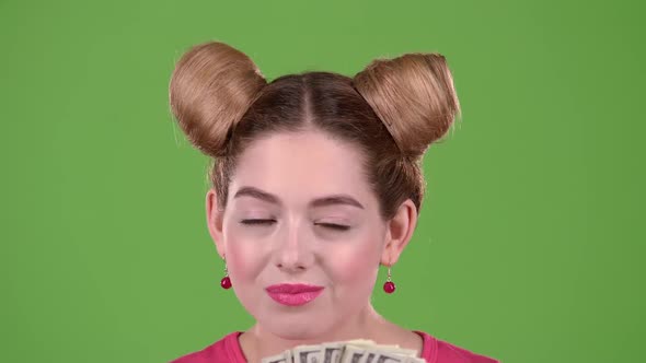 Girl Sniffs Paper Bills and She Is Delighted. Green Screen. Close Up