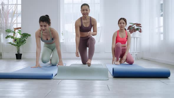 In yoga class, yoga teachers and students are spreading yoga mats to prepare for yoga practice