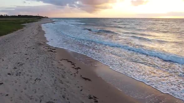 Drone Flying Over Beach At Sunset