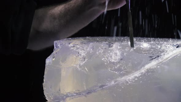 Artist Using Tools to Create an Ice Sculpture Breaking Off Pieces of Ice