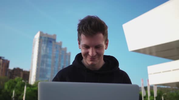 Happy Guy is Using Laptop and Smiling While Enjoying Watching Videos on Internet
