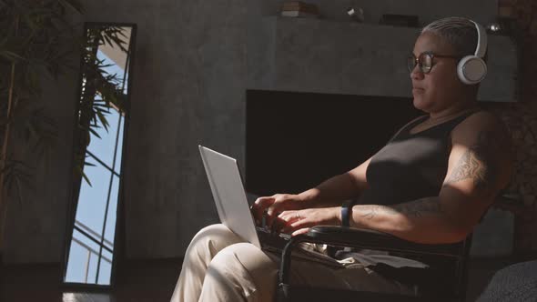 Woman in Wheelchair Typing on Laptop