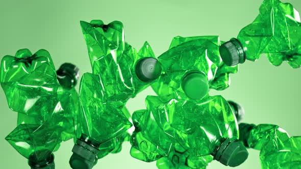 Super Slow Motion Shot of Flying Empty Plastic Bottles on Light Green Background at 1000Fps.