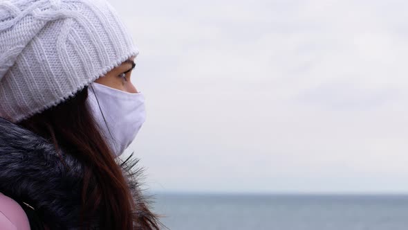 Front view of a woman with long dark hair in a face mask from air pollution Covid19