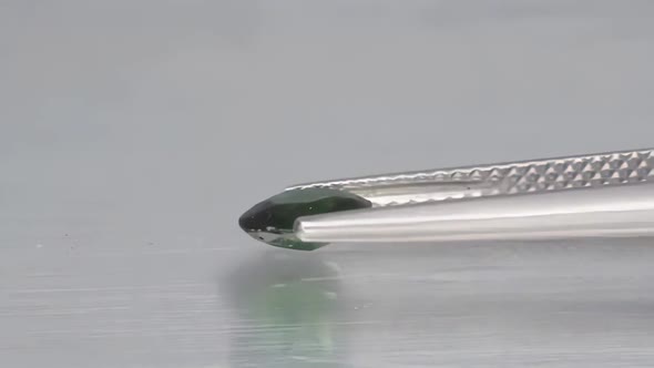 Natural Green Chrome Tourmaline in the Tweezers on the Turn Table