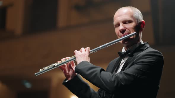 Man is Playing Flute in Music Hall Musician in Symphonic Orchestra or Brass Band Classic Music