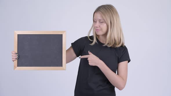 Young Happy Blonde Woman Holding Blackboard and Giving Thumbs Up