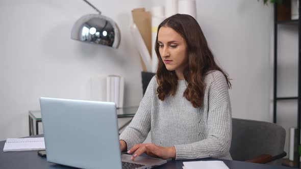 Confident Young Woman Work with a Laptop at the Modern Office