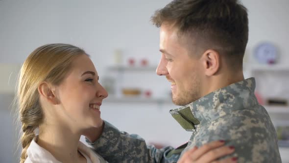 Happy Wife Embracing Male Soldier in Uniform, Homecoming After Military Service