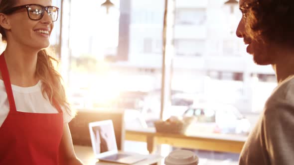 Waitress serving a coffee and sandwich to customer in caf������������