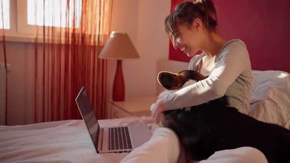 Happy Woman Lying on Bed at Home and Chatting with Boyfriend, Having Video Call on Laptop Computer