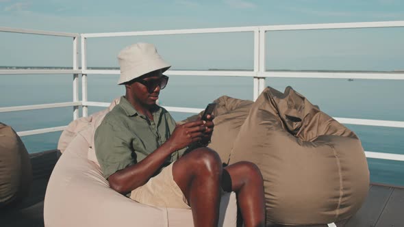 Guy Using Smartphone in Bean Chair