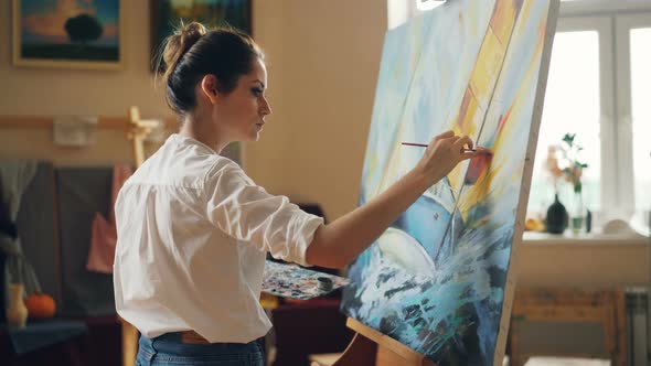 Professional Artist Young Woman Is Painting Seascape with Acrylic Paints