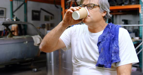 Male mechanic having coffee 