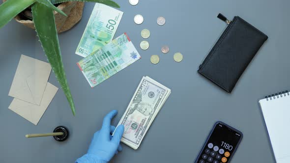 Hands in protective gloves putting money on desk