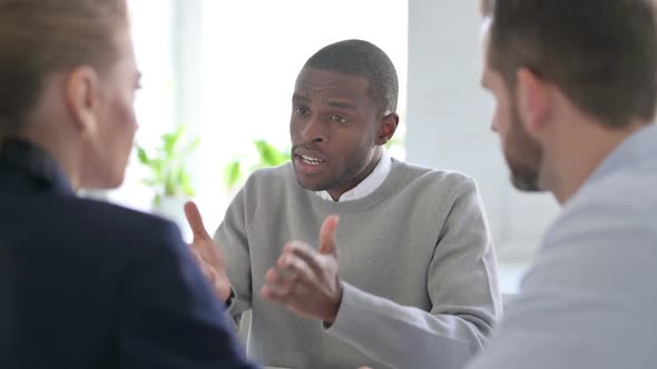 Serious African Businessman Having Discussion with Colleagues