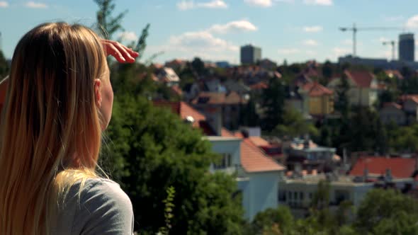 Young Pretty Blond Woman Looks at the City - Closeup