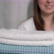 A Young Housewife Woman Holds a Stack of Fresh Washed Clean Linen in Her Hands - VideoHive Item for Sale
