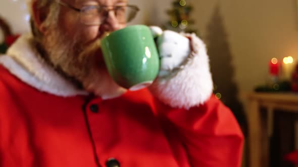 Santa claus relaxing on chair and having coffee