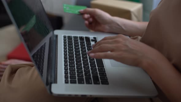 Smiling Woman with Laptop and Credit Card at Home