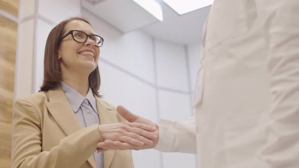 Joyous Woman Saying Thanks and Shaking Hands with Doctor