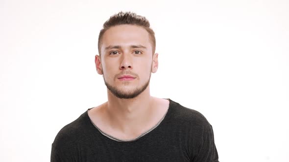 Portrait of Young Handsome Man Looking in Mirror and Checking Shaving