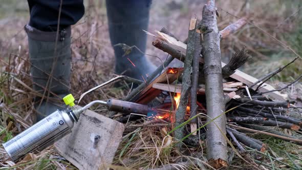 Kindling a Fire in the Autumn Forest with a Gas Burner