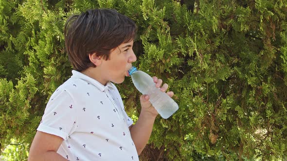 Teenage Boy Drinks Water From Plastic Bottle