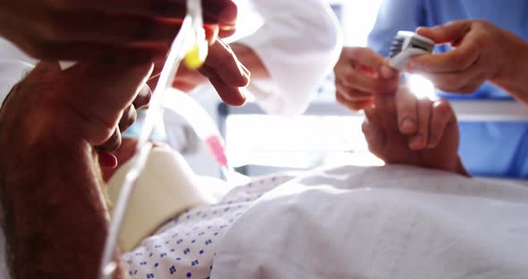 Doctor placing electronic pulse clip on patients finger