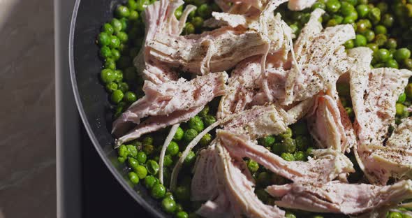 The Fresh Prepared Slices of a Turkey Salted and Pepper Lie on Green Peas in a Frying Pan a Bright