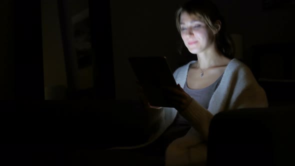 Online Video Chat at Night by Woman on Tablet PC