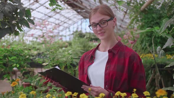 Portrait of a Young Worker of a Greenhouse in Which Flowers and Plants are Grown the Girl Inspector