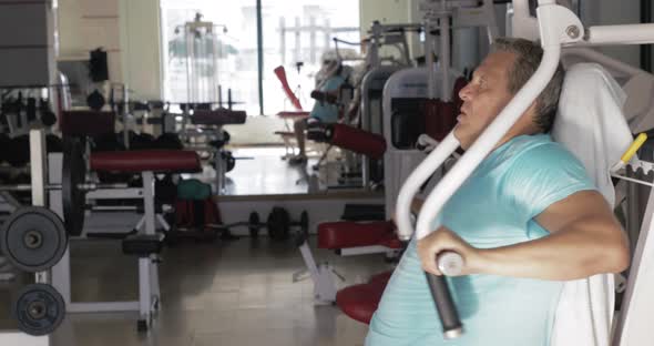 Mature man exercising on chest press machine