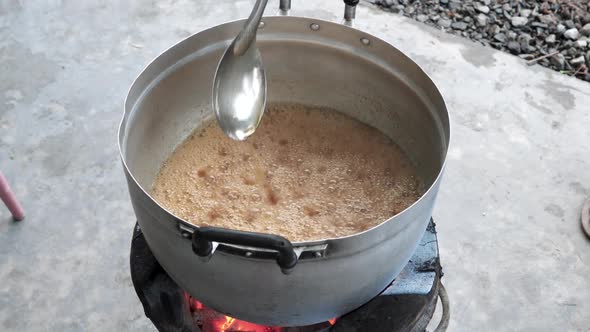 Top view outdoor kitchen, chef mixes boiling tamarind sauce - Thailand dish