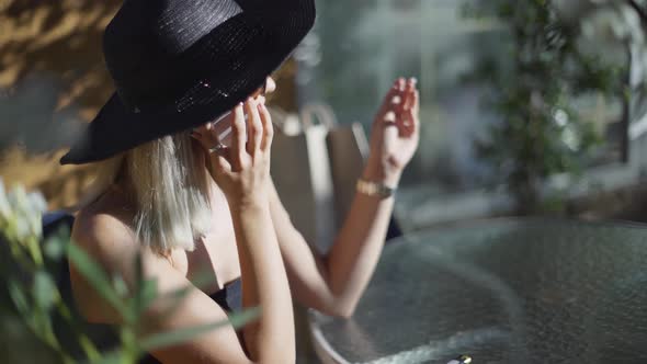 Beautiful Stylish Young Blonde Woman Smoking Cigarettes Outdoors in Han and Sunglasses