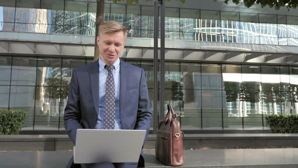 Outdoor Video Chat By Businessman on Laptop