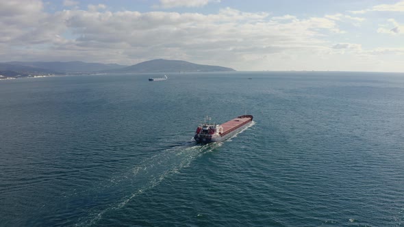 Aerial View of Large Cargo Ship Sailing on Calm Sea Backside View
