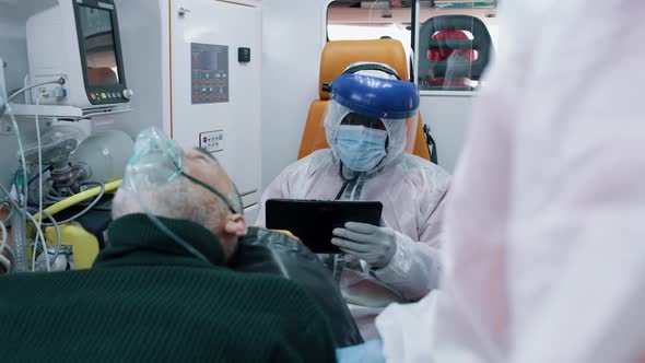 Paramedic Using Tablet Near Coronavirus Patient