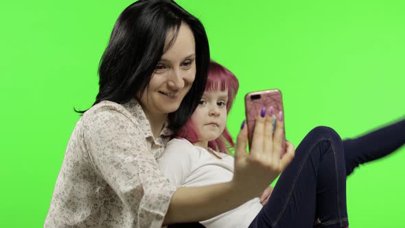 Mother, Daughter Holding, Using Smart Phone Talking on Video Call. Social Media