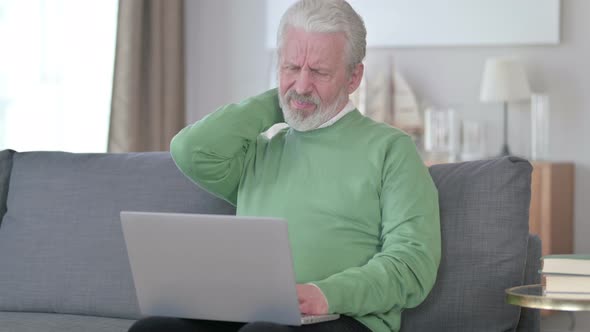 Old Man with Laptop Having Neck Pain at Home