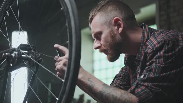 A Young Male Cyclist Takes Pictures of a Vehicle Wheel to Sell or Find a Spare Part for Repair
