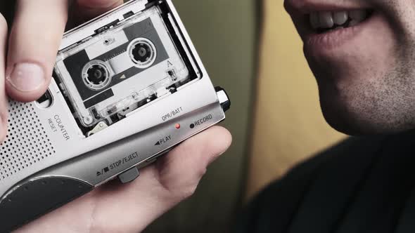 A Young Man Is Recording His Speech on a Portable Retro Cassette Recorder