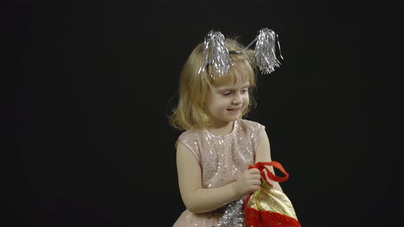 Happy Beautiful Little Baby Girl in Glossy Dress. Christmas. Make Faces, Dance