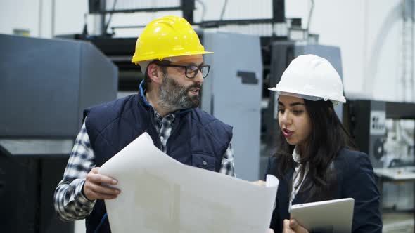 Front View of Printing Workers Inspecting Plan of Building