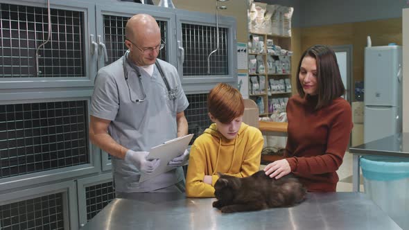 Portrait Of Veterinarian With Cat And Its Owners