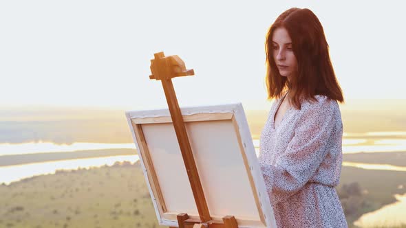 Painting Outside  Young Beautiful Woman Drawing a Painting at Sunset Time Im the Middle of the Field