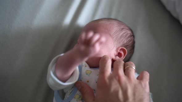 Daddy Hand Scratches the Newborn Behind the Ear and Strokes