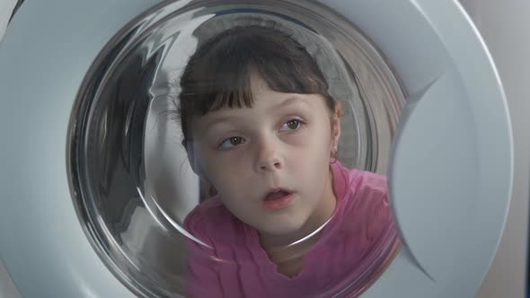 Child Look To a Washing Machine.